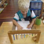 Pelican student using the Hanging Bead Frame